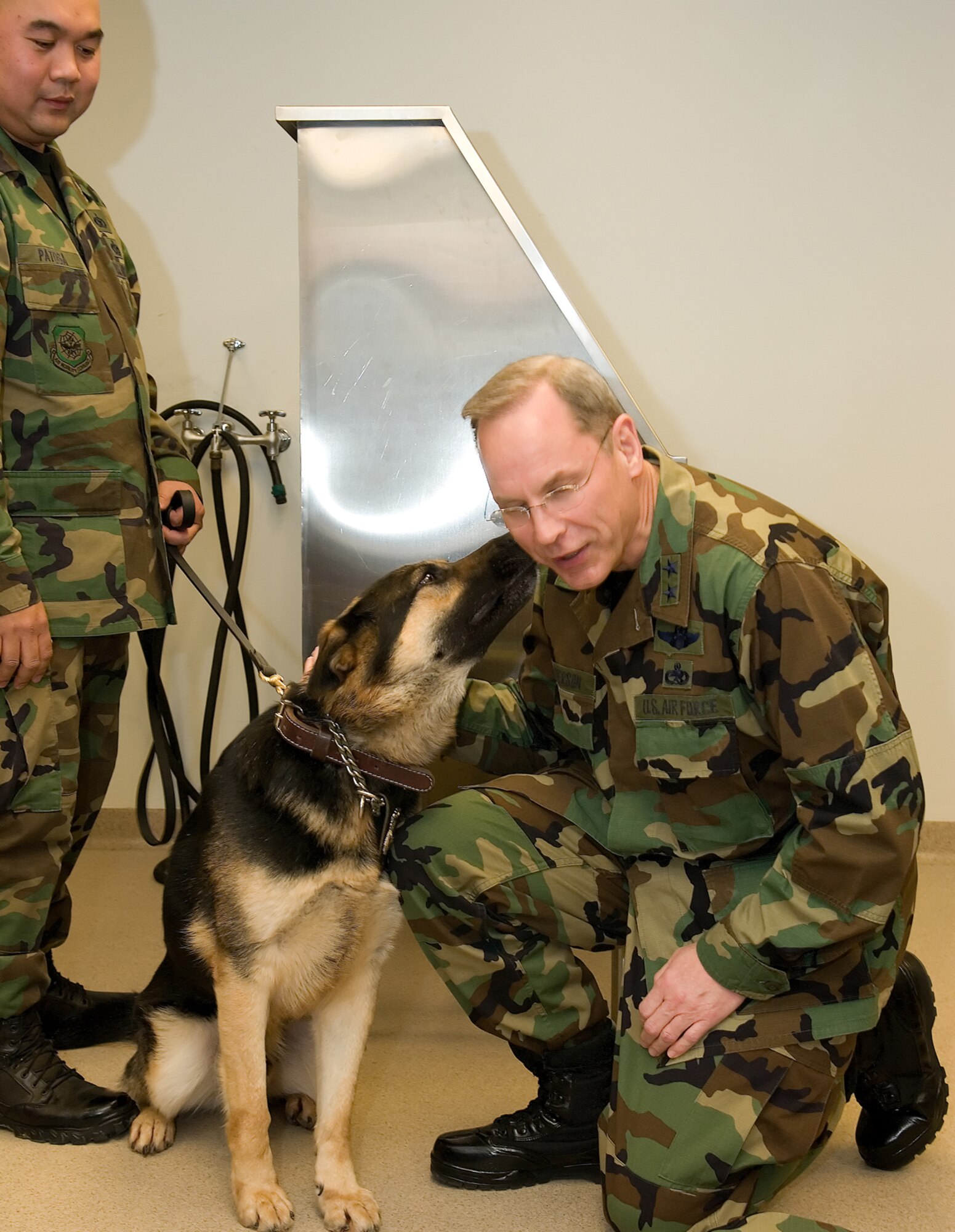 Staff Sgt. Alexander Patosa, 436th Security Forces Squadron, takes a pause from his briefing as his military working dog, Apolo, 'gets to know' Maj. Gen. Mark Anderson, the 2008 Air Force Commander in Chief's Installation Excellence Selection Board team chief. (U.S. Air Force photo/Jason Minto) 
