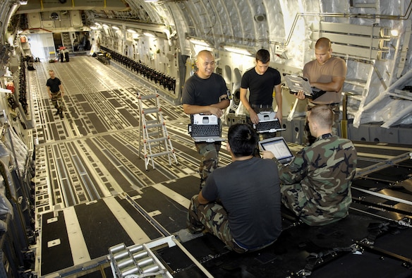 HICKAM AIR FORCE BASE, Hawaii -- Crewchiefs go through maintenance technical orders on a C-17 Globemaster III Jan. 22, 2008 at Hickam Air Force Base, Hawaii. The maintainers, from the combined aircraft maintenance squadron of active duty and Hawaii Air National Guard personnel, are conducting a maintenance orientation for newly assigned Airmen. On Jan. 16, the vice chief of staff of the Air Force presented Pacific Air Forces with the Gen. Wilbur L. Creech Maintenance Excellence award which honors the major command demonstrating the most improved performance in aircraft maintenance and logistics readiness. (U.S. Air Force photo/Tech. Sgt. Shane A. Cuomo) 
