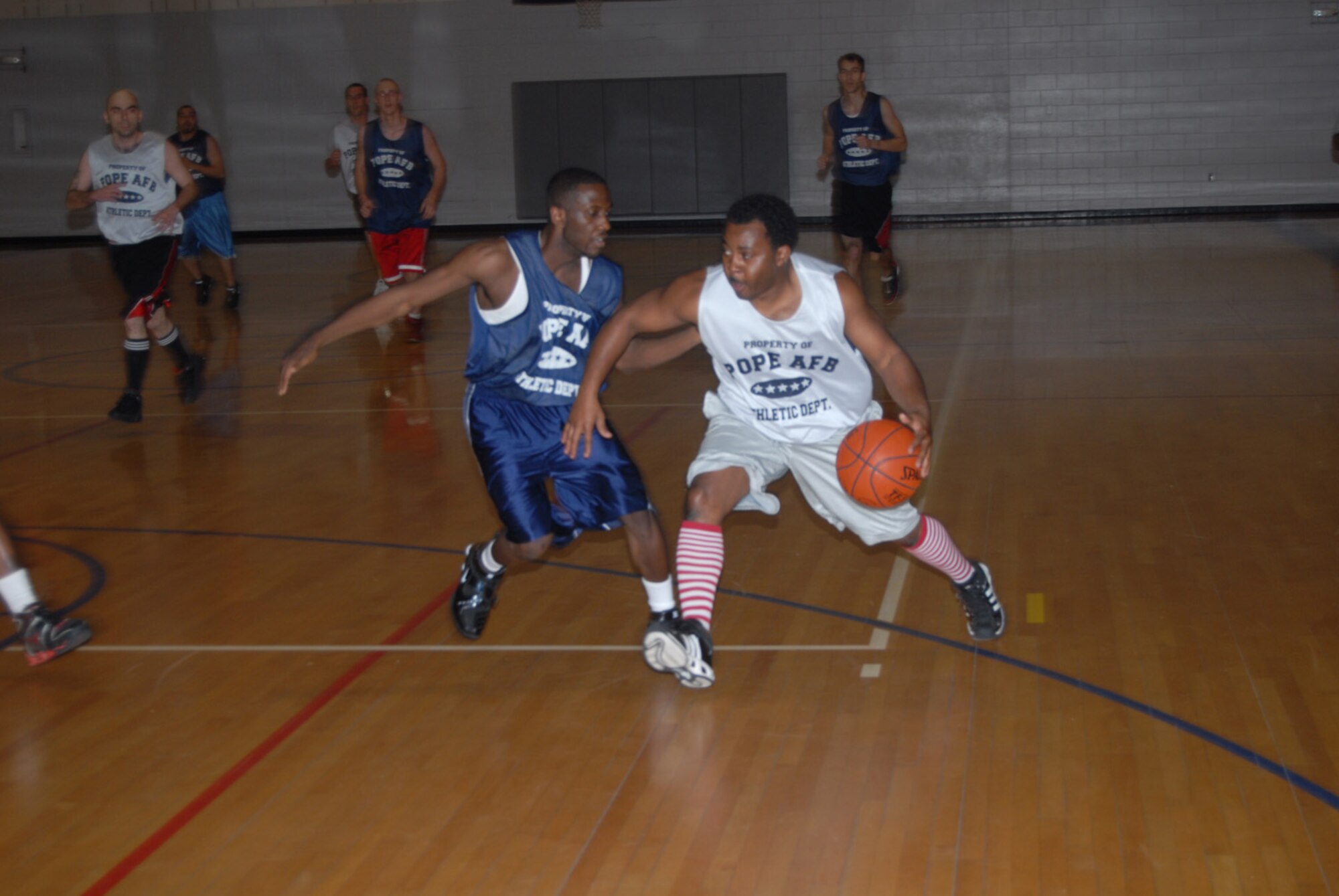 Irvin Gourdine, 43rd Mission Support Squadron, guards Derrick Embry, 23rd Aircraft Maintenance Squadron, during the Jan. 23 game. (U.S. Air Force photo/2nd Lt. Chris Hoyler)
