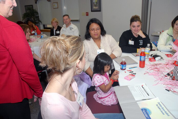 Kenora Lania, daughter of Staff Sgt. Reynaldo Lania, 437th Aerial Port Squadron, and his wife Abigail, read the winning raffle number at the Heart Link orientation program, Jan. 26, at the Charleston AFB Airman and Family Readiness Flight. (U.S. Air Force photo / Staff Sgt. Jennifer Arredondo)