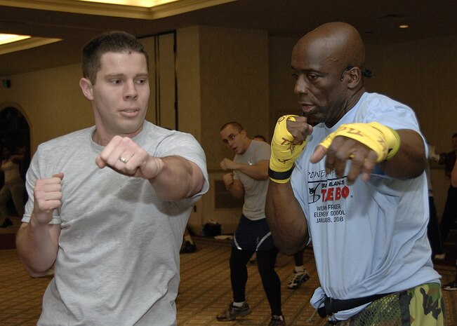 Fitness trainer Billy Blanks instructs 2nd Lt. Branndon Teffeteller, 437th Contracting Squadron, on proper punching techniques during his workout session at the Charleston Club Jan. 28. (U.S. Air Force photo/Airman 1st Class Katie Gieratz)