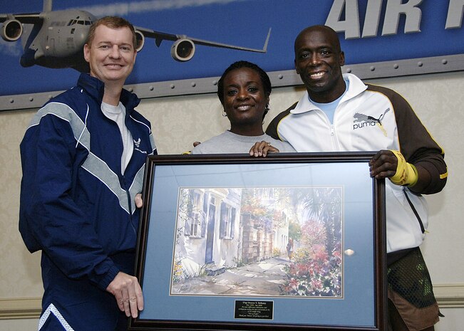 Col. John "Red" Millander (left), 437th Airlift Wing commander, and Billy Blanks, national fitness trainer, present Tech. Sgt. Denese Bellamy, 437th Airlift Wing Military Equal Opportunity Office, a volunteer recognition award Jan. 29 at the Charleston Club. Sergeant Bellamy has been a certified aerobics/indoor cycling instructor and has been volunteering at the Fitness and Sports center since her arrival to Charleston AFB in 1999.  (U.S. Air Force photo/Airman 1st Class Katie Gieratz)