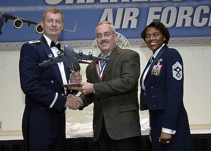 Col. John "Red" Millander, 437th Airlift Wing commander, and Chief Master Sgt. Bernice Belcer, 437th Airlift Wing command chief master sergeant, present the Civilian of the Year, Category three award to Jeffrey Garrett, 437th Civil Engineer Squadron, at the 437 AW Annual Awards dinner at the Charleston Club Jan. 24. (U.S. Air Force photo/Airman 1st Class Katie Gieratz)