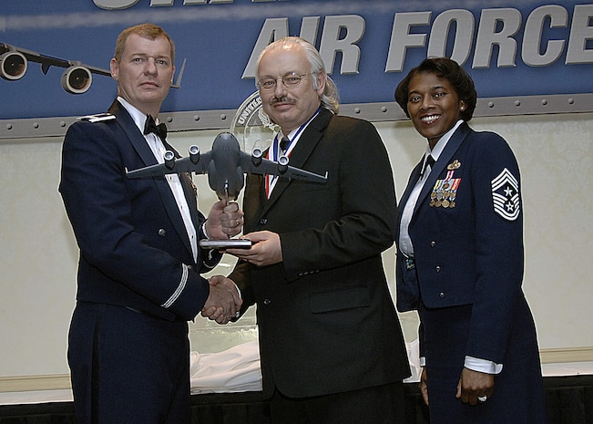 Col. John "Red" Millander, 437th Airlift Wing commander, and Chief Master Sgt. Bernice Belcer, 437th Airlift Wing command chief master sergeant, present the Civilian of Year, Category two award to Kerry Lehman, 437th Security Forces Squadron, at the 437 AW Annual Awards dinner at the Charleston Club Jan. 24. (U.S. Air Force photo/Airman 1st Class Katie Gieratz)