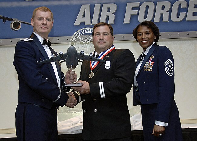 Col. John "Red" Millander, 437th Airlift Wing commander, and Chief Master Sgt. Bernice Belcer, 437th Airlift Wing command chief master sergeant, present the Civilian of Year, Category one award to Michael Ruey, 437th Civil Engineer Squadron, at the 437 AW Annual Awards Dinner at the 437 AW Annual Awards dinner at the Charleston Club Jan. 24. (U.S. Air Force photo/Airman 1st Class Katie Gieratz)