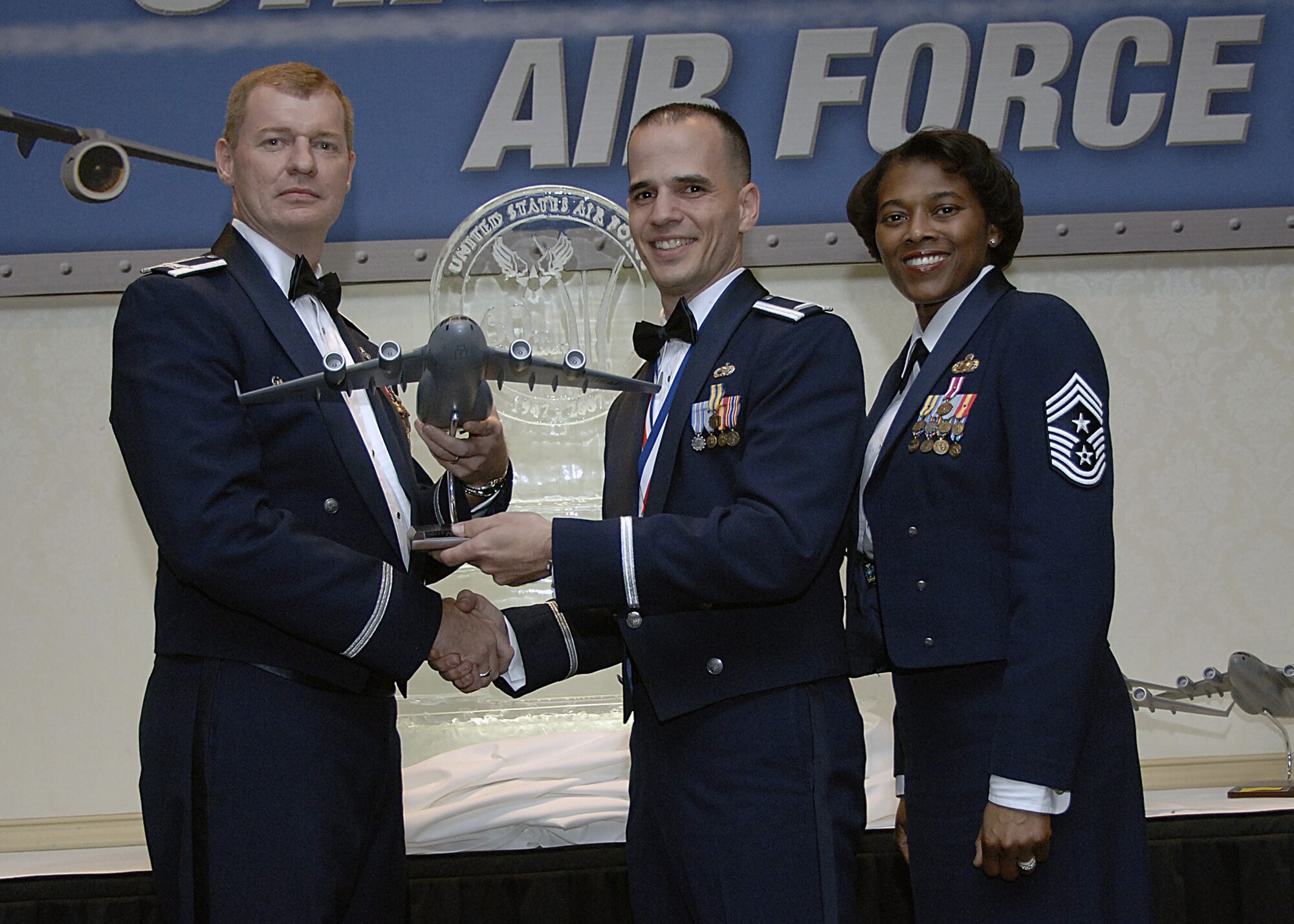 Col. John "Red" Millander, 437th Airlift Wing commander, and Chief Master Sgt. Bernice Belcer, 437th Airlift Wing command chief master sergeant, present the Junior Company Grade Officer of the Year award to 1st Lt. Vincent Cammarano, 437th Aircraft Maintenance Squadron, at the 437 AW Annual Awards dinner at the Charleston Club Jan. 24. (U.S. Air Force photo/Airman 1st Class Katie Gieratz)