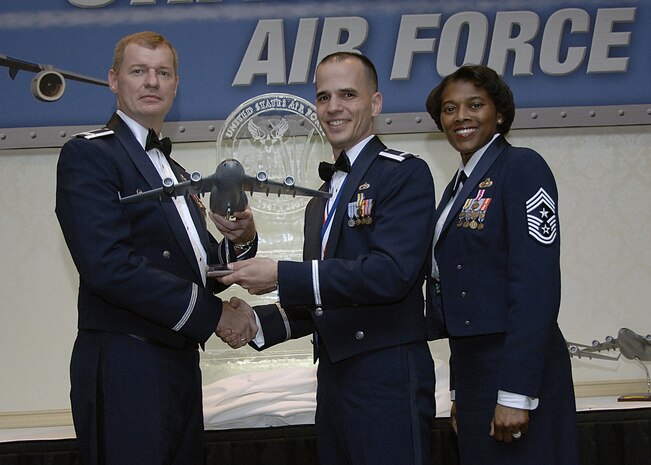 Col. John "Red" Millander, 437th Airlift Wing commander, and Chief Master Sgt. Bernice Belcer, 437th Airlift Wing command chief master sergeant, present the Junior Company Grade Officer of the Year award to 1st Lt. Vincent Cammarano, 437th Aircraft Maintenance Squadron, at the 437 AW Annual Awards dinner at the Charleston Club Jan. 24. (U.S. Air Force photo/Airman 1st Class Katie Gieratz)