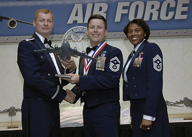 Col. John "Red" Millander, 437th Airlift Wing commander, and Chief Master Sgt. Bernice Belcer, 437th Airlift Wing command chief master sergeant, present the First Sergeant of the Year award to Senior Master Sgt. Robert Frank, 437th Aircraft Maintenance Squadron first sergeant, at the 437 AW Annual Awards dinner at the Charleston Club Jan. 24. (U.S. Air Force photo/Airman 1st Class Katie Gieratz)