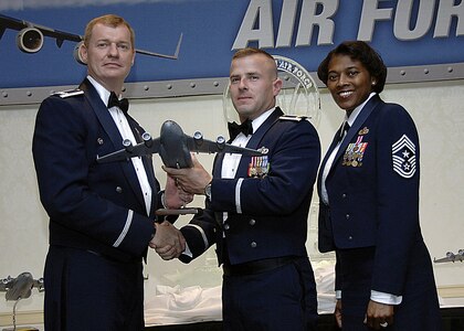 Col. John "Red" Millander, 437th Airlift Wing commander, and Chief Master Sgt. Bernice Belcer, 437th Airlift Wing command chief master sergeant, present the Senior NCO of the year award to Maj. Chad Morris, 437 Aerial Port Squadron, who accepted the award on behalf of Master Sgt. Timothy Gibson, 437th Aerial Port Squadron, who is currently deployed, at the 437 AW Annual Awards dinner at the Charleston Club Jan. 24. (U.S. Air Force photo/Airman 1st Class Katie Gieratz)