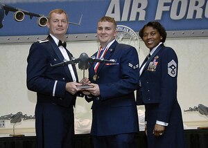 Col. John "Red" Millander, 437th Airlift Wing commander, and Chief Master Sgt. Bernice Belcer, 437th Airlift Wing command chief master sergeant, present the 437th Airlift Wing Airman of the Year award to Airman 1st Class Lawrence Hunt, 437th Aerial Port Squadron, at the 437 AW Annual Awards dinner at the Charleston Club Jan. 24. (U.S. Air Force photo/Airman 1st Class Katie Gieratz)