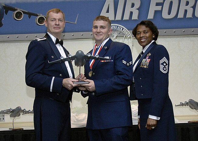 Col. John "Red" Millander, 437th Airlift Wing commander, and Chief Master Sgt. Bernice Belcer, 437th Airlift Wing command chief master sergeant, present the 437th Airlift Wing Airman of the Year award to Airman 1st Class Lawrence Hunt, 437th Aerial Port Squadron, at the 437 AW Annual Awards dinner at the Charleston Club Jan. 24. (U.S. Air Force photo/Airman 1st Class Katie Gieratz)