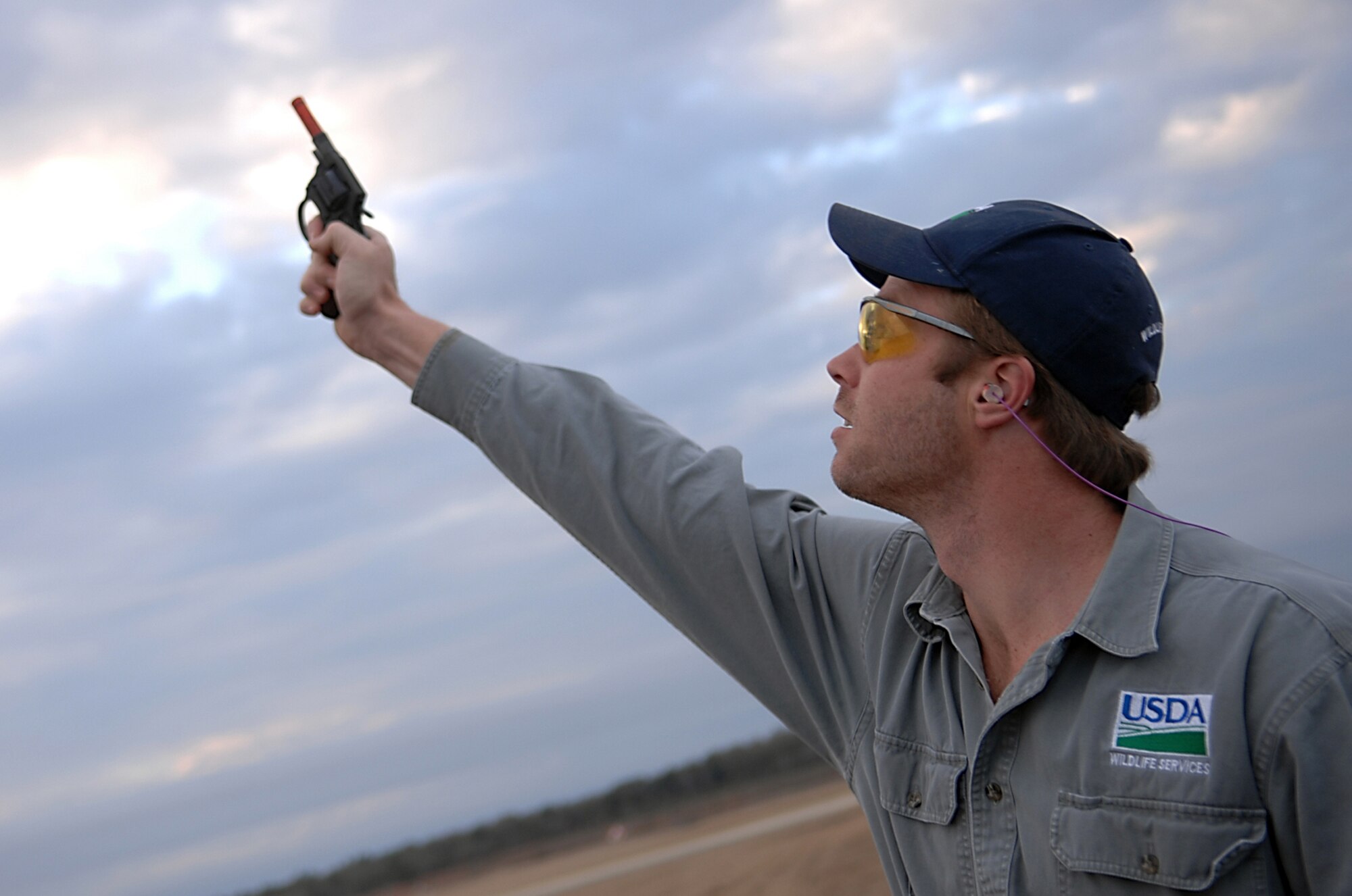 MOODY AIR FORCE BASE, Ga. -- Odin Stephens, 23rd Wing wildlife biologist, shoots a pyrotechnic starter pistol here Jan. 30. Mr. Stephens uses pyrotechnics called screamers, bangers and shellcrackers to scare wildlife away from the flightline. (U.S. Air Force photo by Airman 1st Class Brittany Barker) 