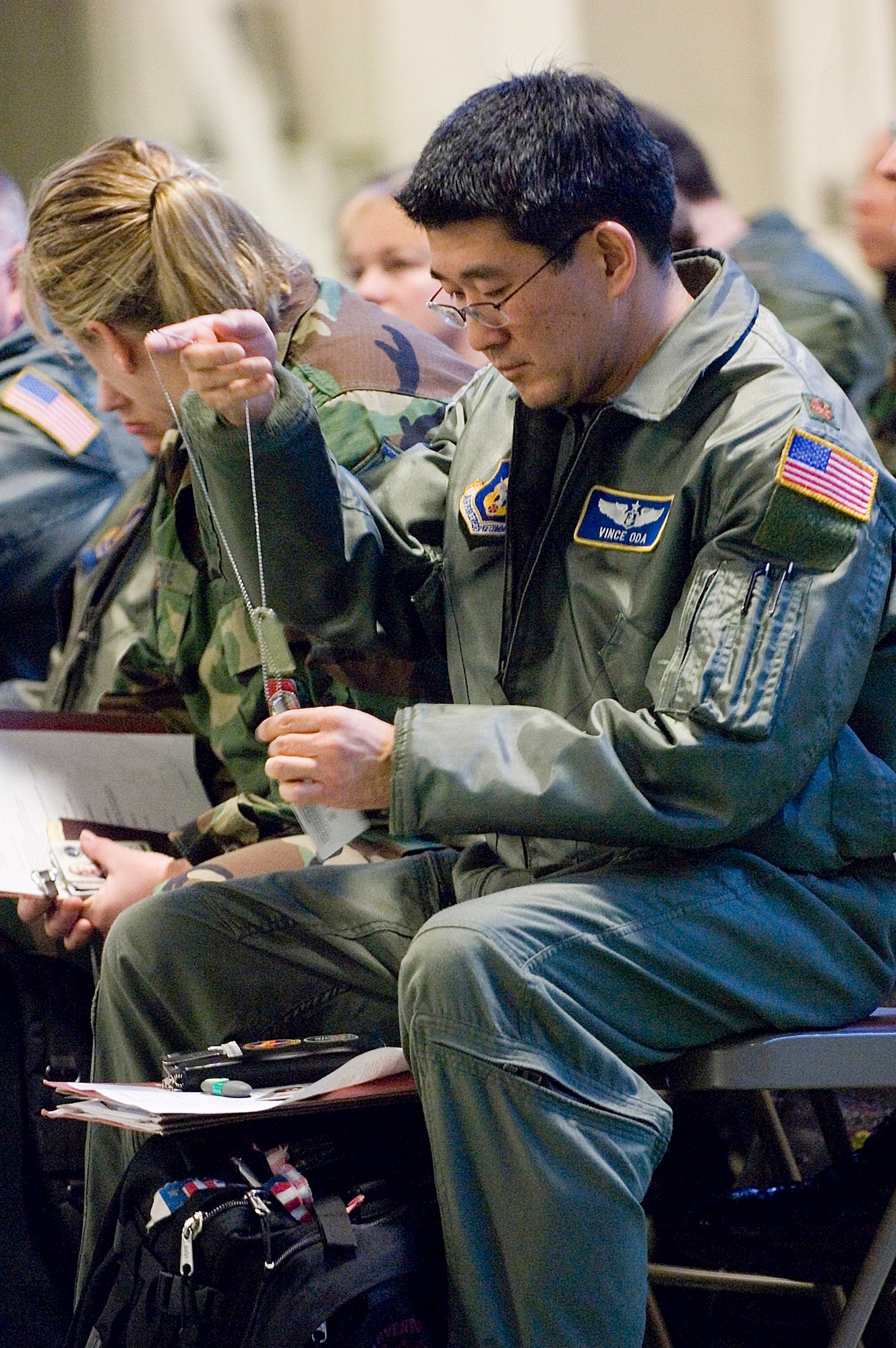 Maj. Vincent Oda pulls out his dog tags Jan. 25 at the deployment processing center at McChord Air Force Base, Wash. Major Oda and 140 other reservists from the 446th Airlift Wing are participating in the Pacific Lifeline exercise in Hawaii Jan. 26 through Feb. 9. Pacific Lifeline is a total force exercise designed to exercise the military's ability to rapidly deploy a trained, equipped team anywhere in the Pacific in response to a humanitarian assistance or disaster scenario. Major Oda is assigned to the 446th Aeromedical Evacuation Squadron. (U.S. Air Force photo/Abner Guzman) 
