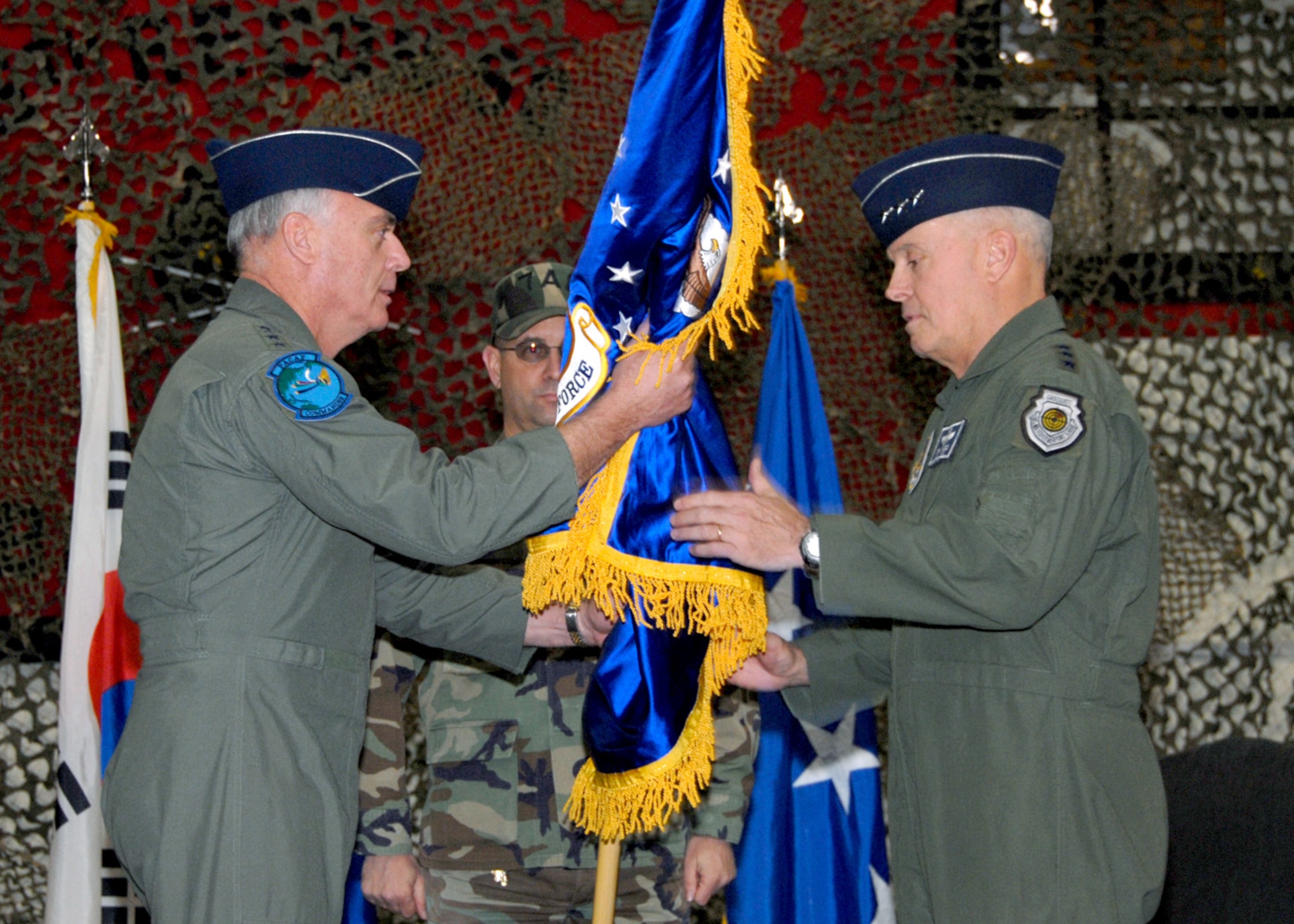OSAN AIR BASE, Republic of Korea -- (L to R) General Carrol H. “Howie” Chandler, Pacific Air Forces commander, passes the new Seventh Air Force (Air Forces Korea) guidon to Lt. Gen. Stephen G. Wood, Seventh Air Force (Air Forces Korea) commander, during the Seventh Air Force Re-designation Ceremony Jan. 30 in the 5th Reconnaissance Squadron hangar. This ceremony marks the implementation of the Chief of Staff of the Air Force's direction to establish an Air Force component organization that is structured to operate and train every day in its wartime configuration.  These warfighting organizations are being stood up around the globe to enable the effective command and control of air, space, and cyberspace forces conducting missions across the spectrum of military operations.  The new Seventh Air Force (Air Forces Korea) organization will provide the United States Forces Korea commander with critical air component capabilities, ensuring a key element of joint and combined operations on the Korean peninsula.  (U.S. Air Force photo/Staff Sgt. Lakisha Croley)