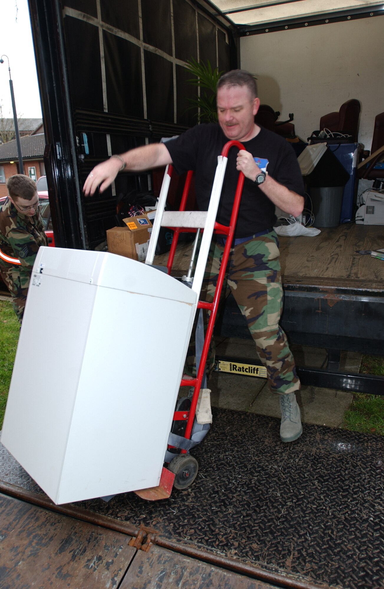 Ch. (Lt. Col.) Michael Moore, 100th Air Refueling Wing chaplain (right), hefts a paper shredder onto a lift as Staff. Sgt. Lyle Ruthford, 100th ARW chapel, prepares to raise it into place Jan 29. The chapel has spent the last several weeks moving into their newly renovated chapel. 
