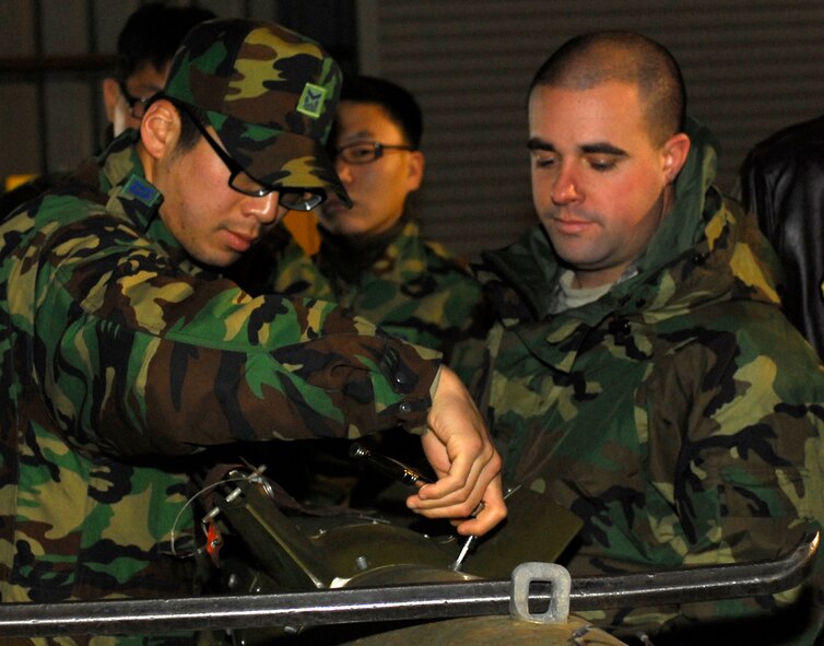 KUNSAN AIR BASE, South Korea --Staff Sgt. Nathan Degregory and Staff Sgt. Gong-myung Park, assemble a Guided Bomb Unit during Iron Viper here Jan. 30.  The Iron Viper program is a quarterly event that allows pilots to experience actual munitions build-up within the Munitions Storage Area using the same facilities and munitions that would be used during contingency operations. Pilots are able to experience "hands on" training as AMMO experts take them through the start-to-finish breakout, assembly and delivery of various bombs, missiles, chaff, flare, and 20mm bullets. (U.S. Air Force photo/Senior Airman Giang Nguyen)