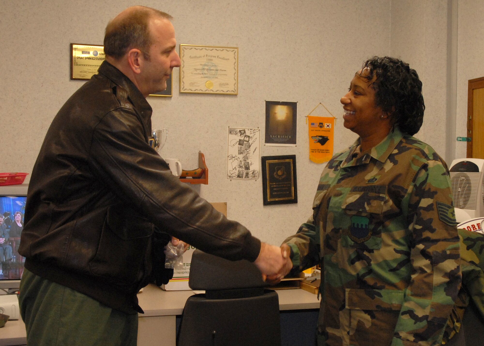 KUNSAN AIR BASE, South Korea --  Colonel Creig Rice, 8th Fighter Wing vice  commander, congratulates Tech. Sgt. Jennifer Mason, 8th Services Squadron NCO in charge of the Community Activity Center and base coordinator, here Jan. 30. Sergeant Mason was selected as the 8th Fighter Wing's Pride of the Pack for the week of Jan. 28. (U.S. Air Force photo/Staff Sgt. Araceli Alarcon) 