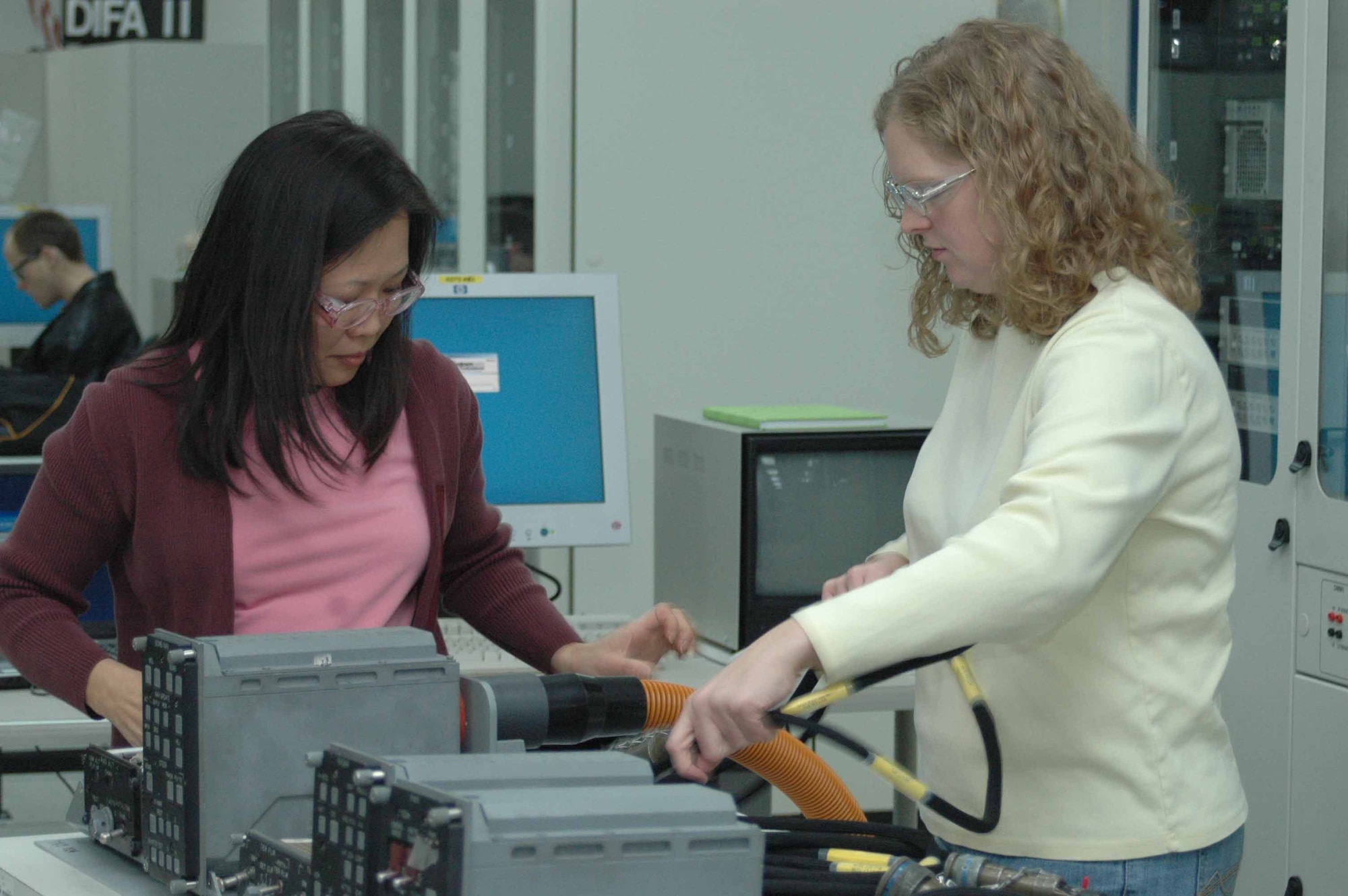 Antthu Vo and Allison Wilson, electronics engineers with the 556th Software Maintenance Squadron prepare several B-1 Bomber line replaceable units for testing.
(Air Force photo by Ron Mullan)
