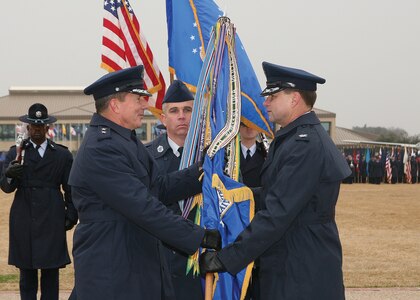 Maj. Gen. Michael Gould, 2nd Air Force commander, hands over command of the 37th Training Wing to Col. Len Patrick at a change of command ceremony Jan. 25 at the Lackland AFB, Texas, Parade Grounds. (USAF photo by Robbin Cresswell)