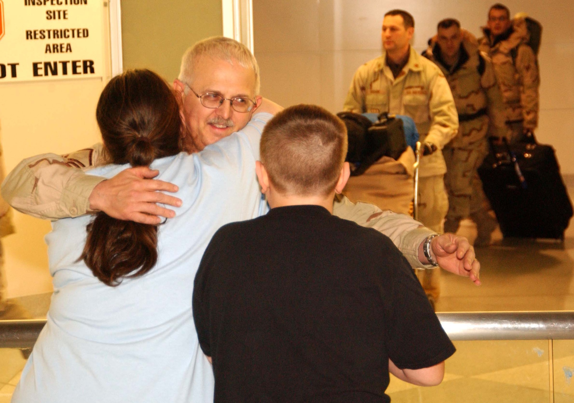 BALTIMORE-WASHINGTON INTERNATIONAL AIRPORT, Md. -- Master Sgt. Keith Loney, 459th Air Refueling Wing historian, gets hearty hugs from his family members upon his return from deployment to Afghanistan Jan. 16. (U.S. Air Force photo/Capt. Tim Smith)