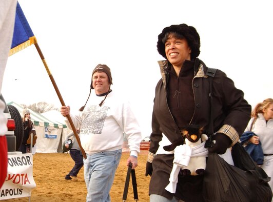 ANNAPOLIS, Md. -- Tech. Sgt. Warren Hiller, 459th Aircraft Maintenance Squadron, and Col. Stayce D. Harris, 459th Air Refueling Wing commander, walk toward the shore during the Maryland State Police Polar Bear Plunge Jan. 26. Team Andrews members of the 459th Air Refueling Wing and the 79th Medical Wing were among nearly 9,000 people who voluntarily jumped into the Chesapeake Bay at Sandy Point Park to raise money for Special Olympics Maryland.  (U.S. Air Force photo/Staff Sgt. Amaani Lyle)