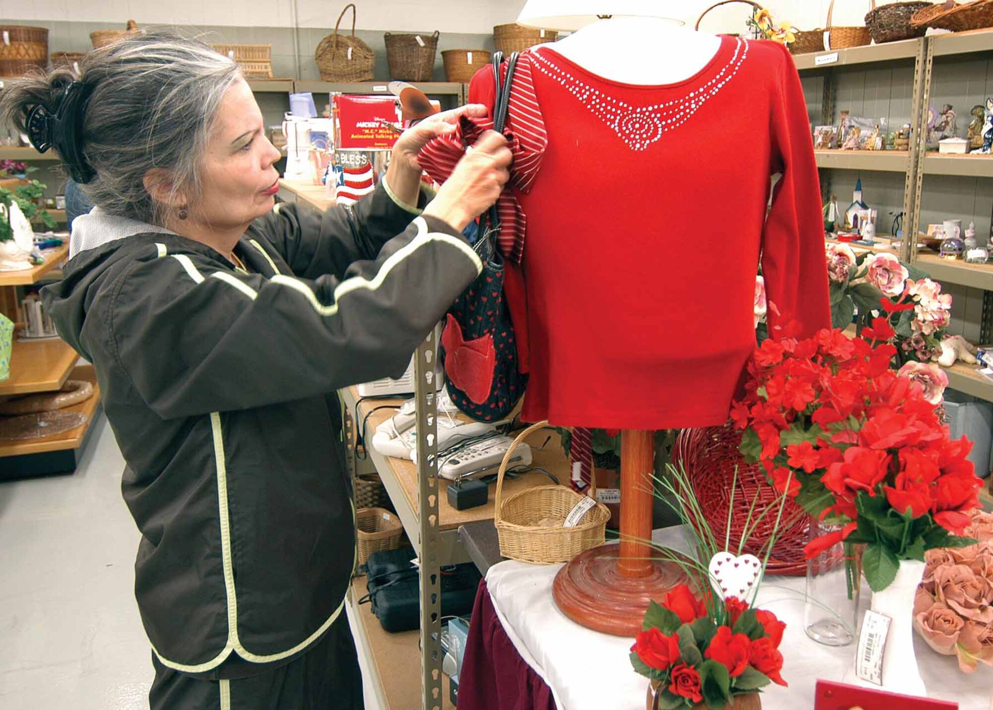 Tinker Officers’ Spouses’ Club Thrift Shop volunteer Jamia Brett perfects a display in the furniture area of the shop.  Proceeds from sales fund the club’s scholarship program which awarded $13,000 to students last year.  The thrift shop, housed in Bldg. 6002, will close Feb. 4 for approximately one month as the building is re-roofed.  March 14 is the projected re-open date, but shop manager Lupe Bell said customers will be updated by mail.  For questions before Feb. 4, please call the shop at 734-3996. (Air Force photo by Margo Wright)