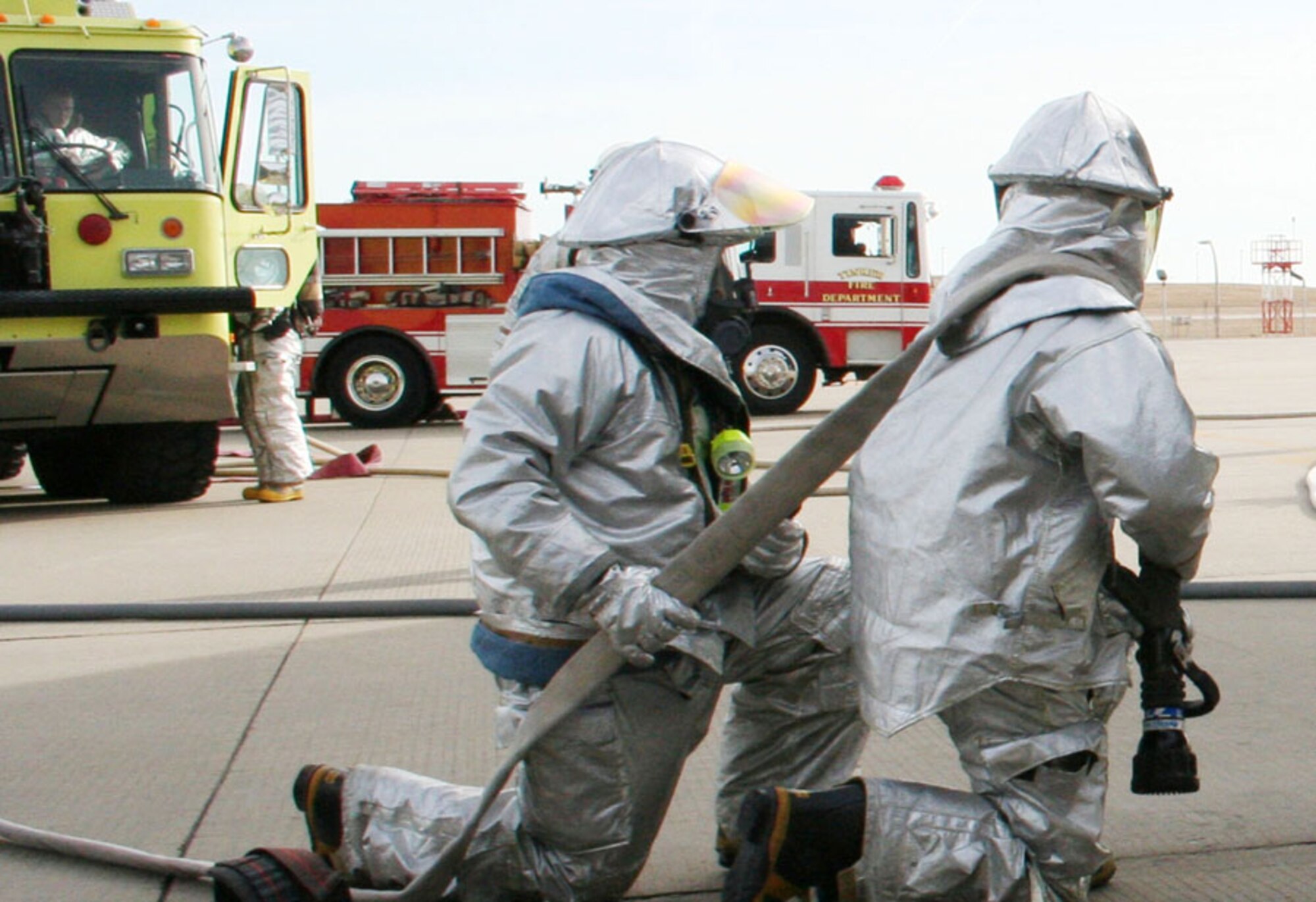 Two 507th Air Refueling Wing firefighters stage themselves in readiness should the crew extraction simulation exercise they are paticipating in escalate into a scenario requiring fire suppression.