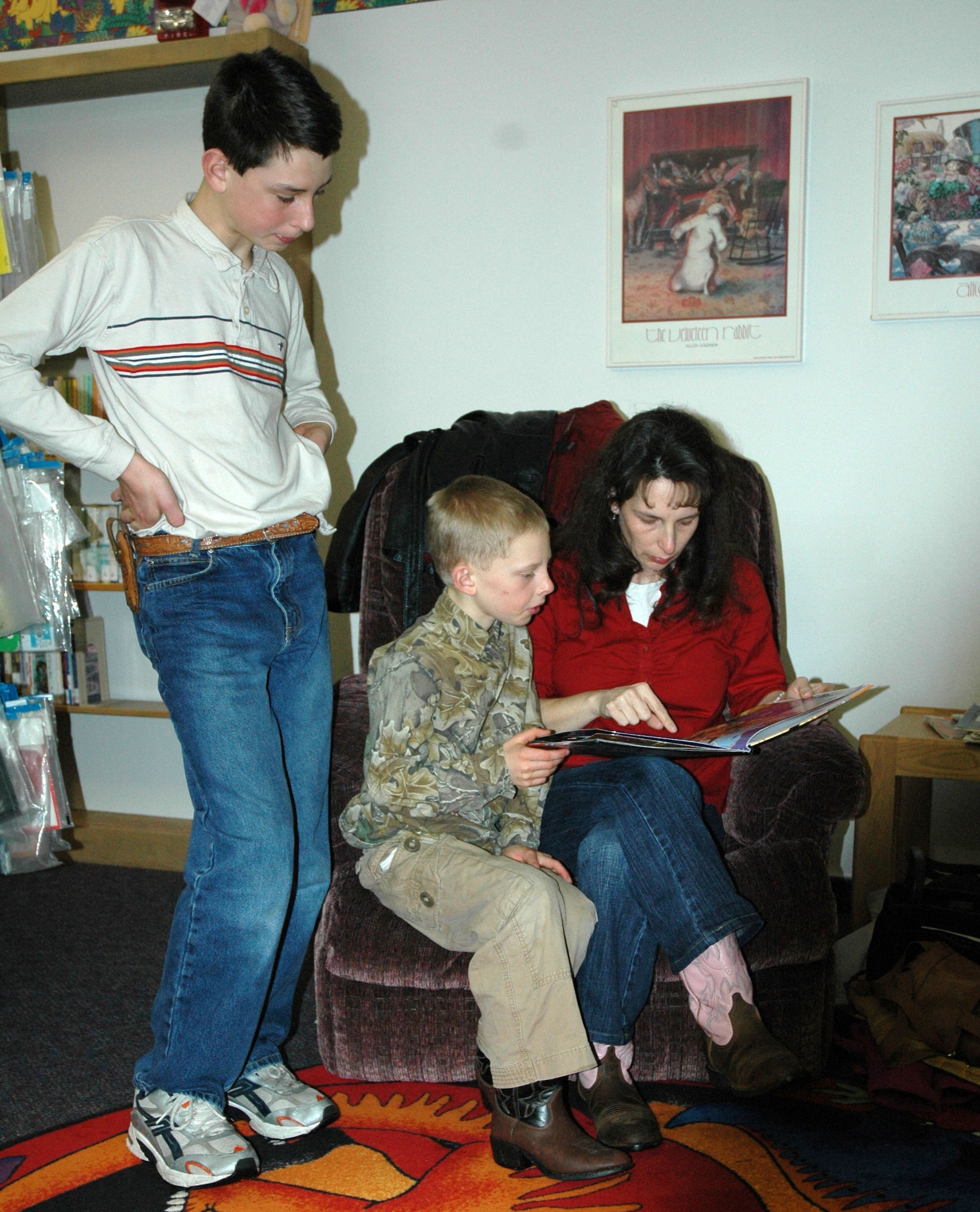 Renee Hallett, a home-school parent, reads to Little Warrior Carter, 7, as Zakery, 13, looks on at the Arden G. Hill Memorial Library Jan. 24. (U.S. Air Force photo/Airman 1st Class Dillon White)