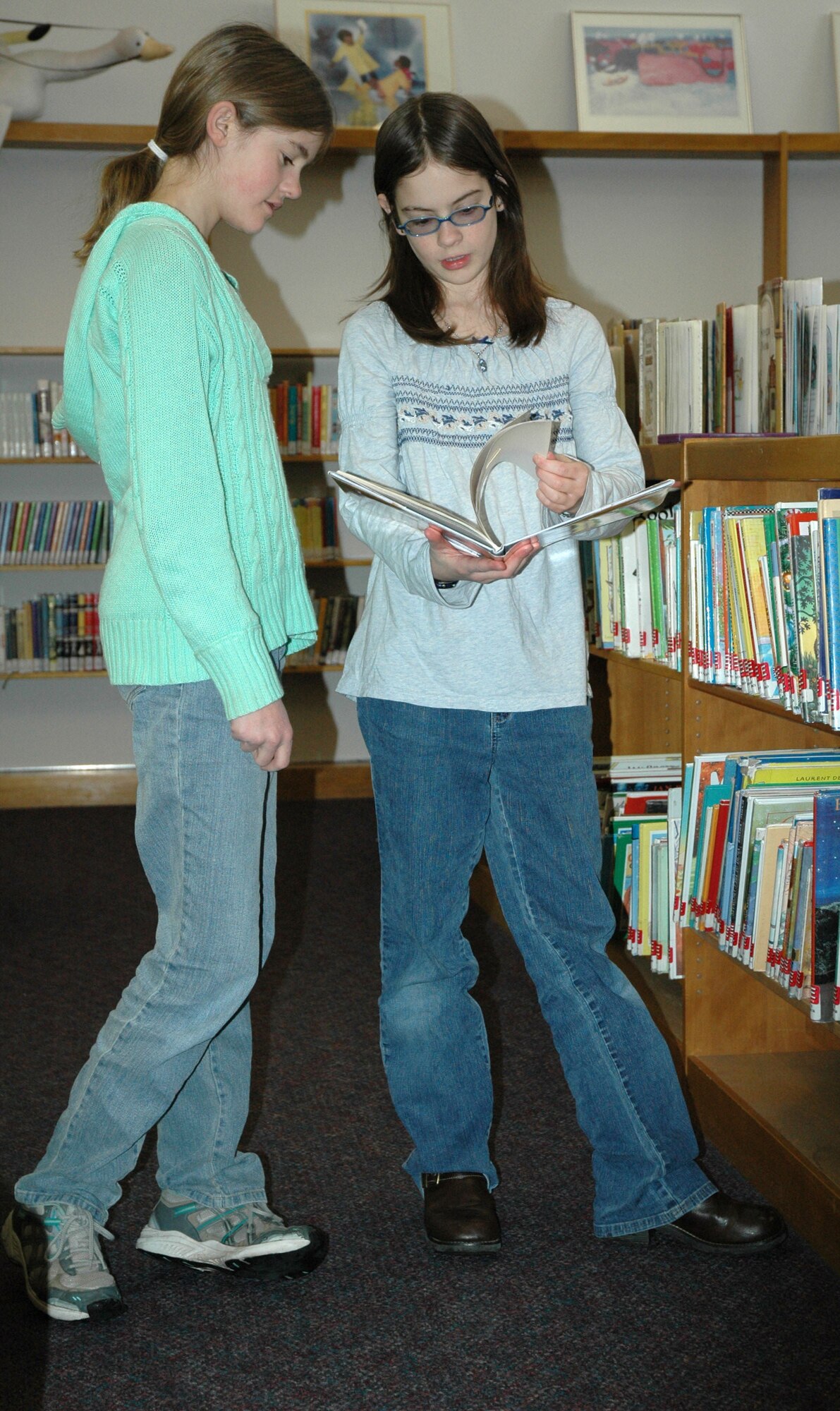 Home schooled students Mackenzie and Sarah, both 10, look through a book at the Arden G. Hill Memorial Library Jan. 24. (U.S. Air Force photo/Airman 1st Class Dillon White)