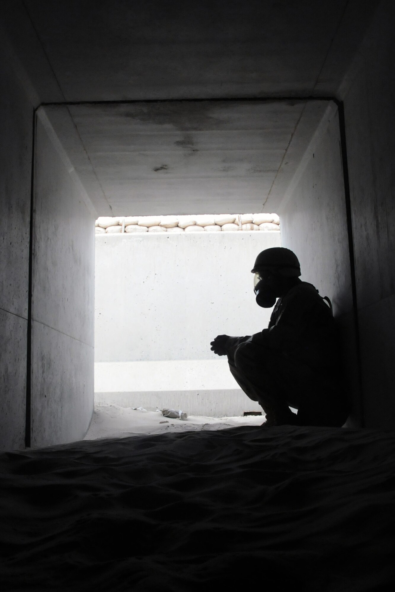 SOUTHWEST ASIA -- Master Sgt. Steven Kenney, 379th Air Expeditionary Wing command post, takes shelter in a bunker in coalition compound at a Southwest Asia air base Jan. 31. Members deployed here participate in regular integrated base defense exercises responding to simulated conventional and chemical threats. (U.S. Air Force photo/SrA Domonique Simmons)