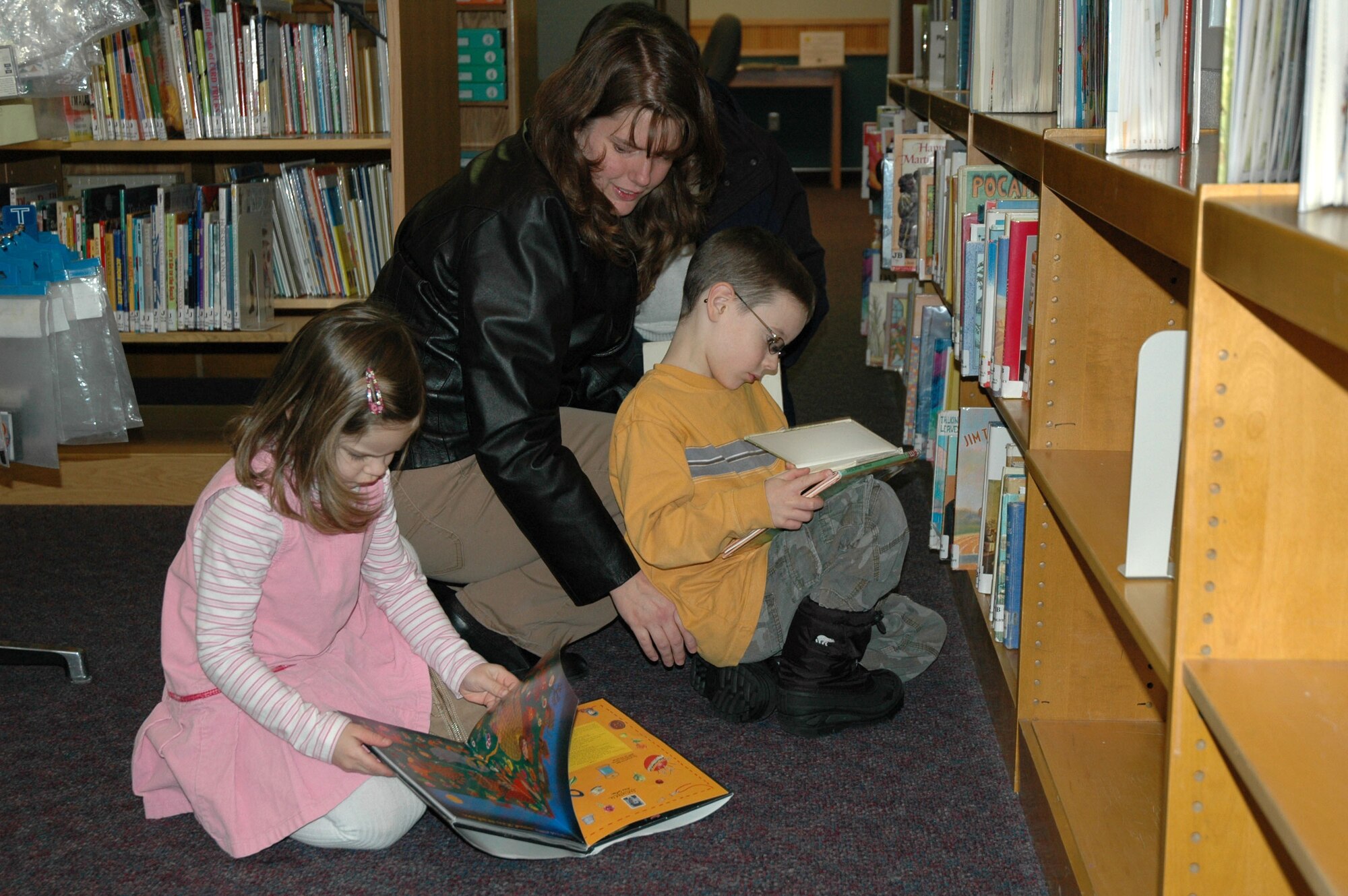 Jill Clark, a home-school parent, and Little Warriors Benjamin, 6, and Rebekah, 4, both home-schooled students, look for books during an outing at the Arden G. Hill Memorial Library Jan. 24. (U.S. Air Force photo/Airman 1st Class Dillon White)