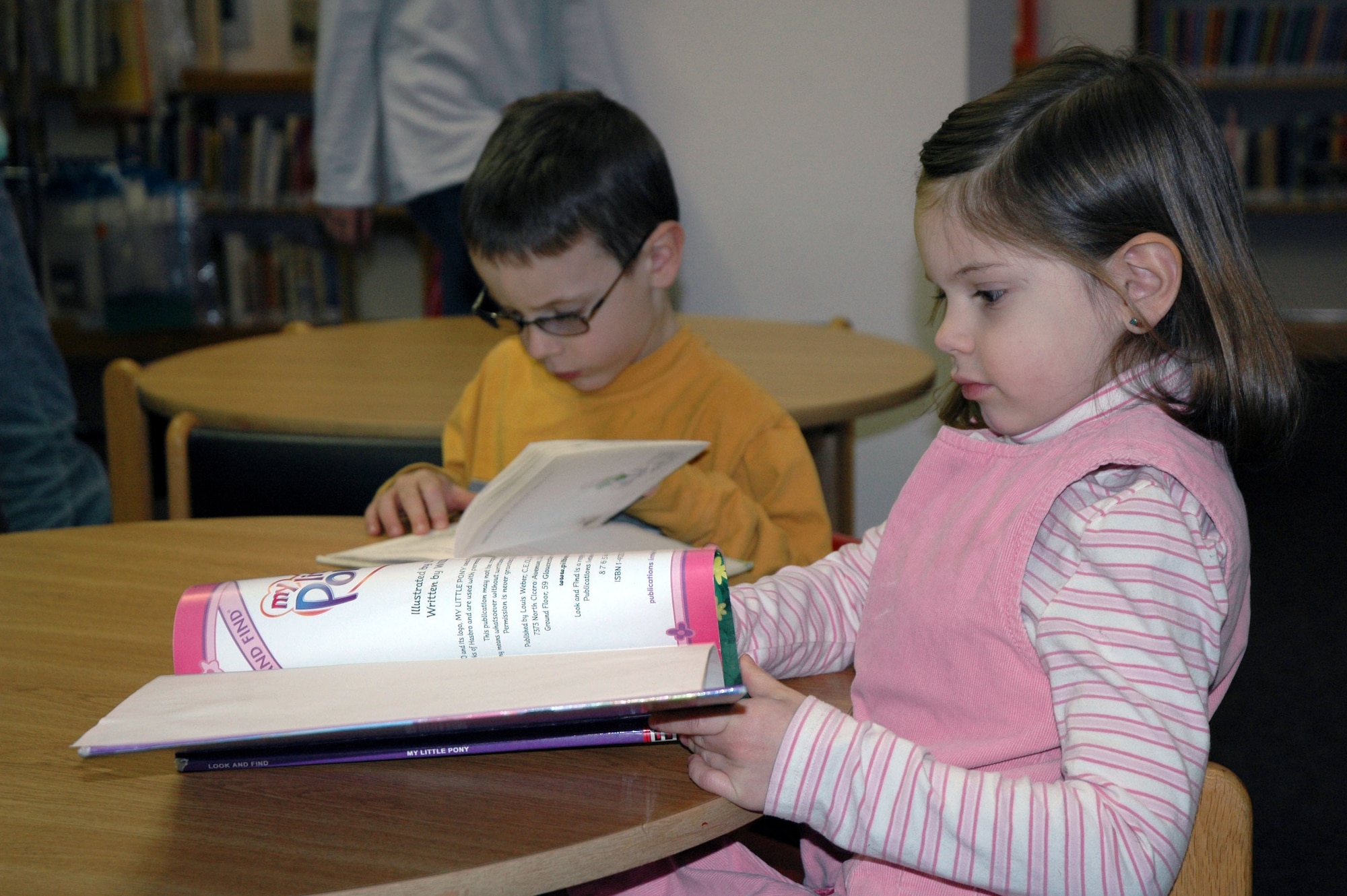 Little Warriors Benjamin, 6, and Rebekah, 4, both home-schooled students, read books during an outing at the Arden G. Hill Memorial Library Jan. 24. (U.S. Air Force photo/Airman 1st Class Dillon White)