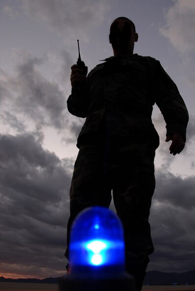 Staff Sgt. Thomas Hensley, 56th Operations Support Squadron airfield operations management supervisor, inspects one of the blue runway lights to ensure it works properly. The runway lights are checked every evening at dusk. (photo by Airman 1st Class David Bulkley)
