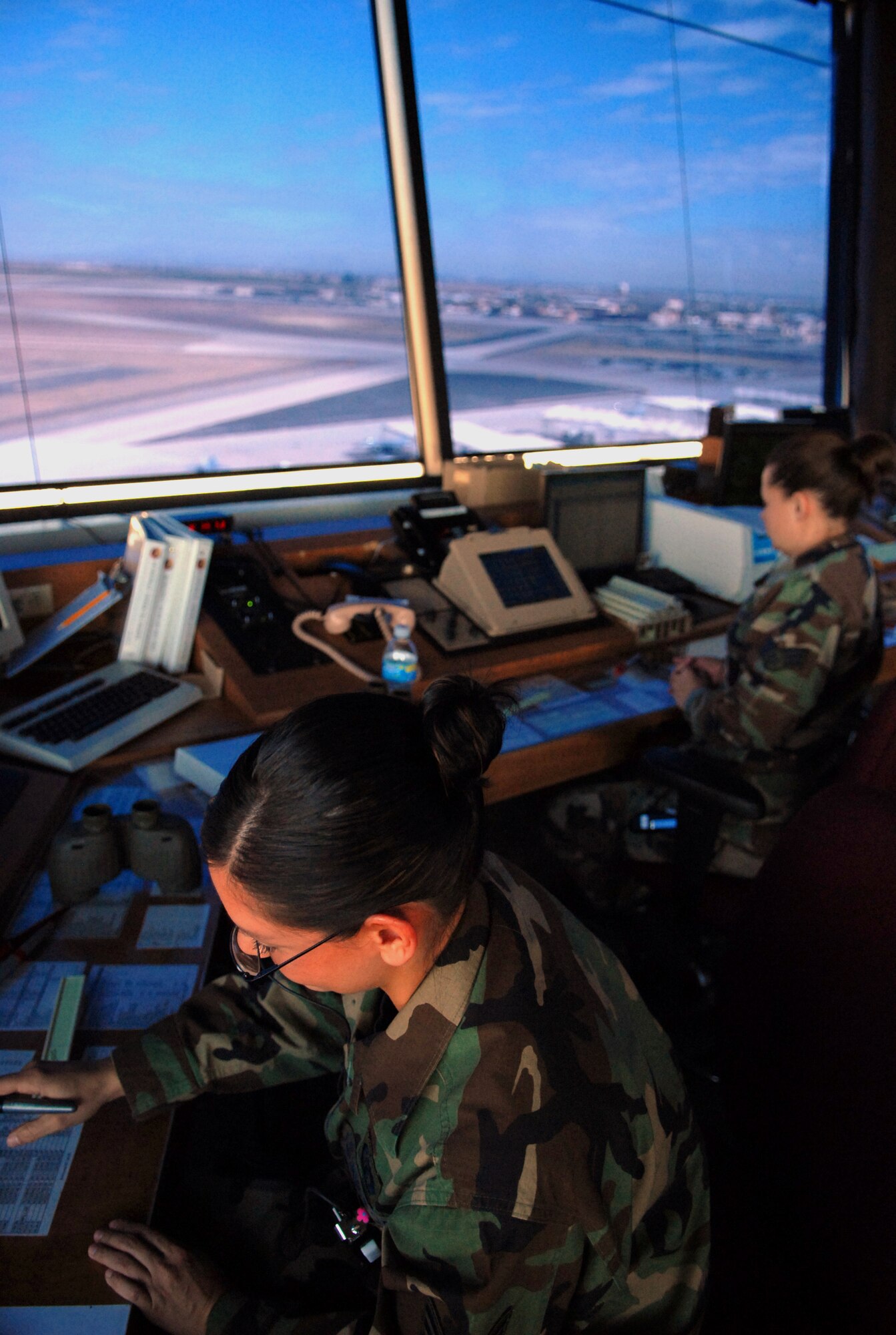 Senior Airman April Vasquez, 56th Operations Support Squadron air traffic controller, writes flight information on a small plastic strip. Information such as the F-16 flight path and call sign is used so other controllers know what jets are in the air. (photo by Airman 1st Class C.J. Hatch)