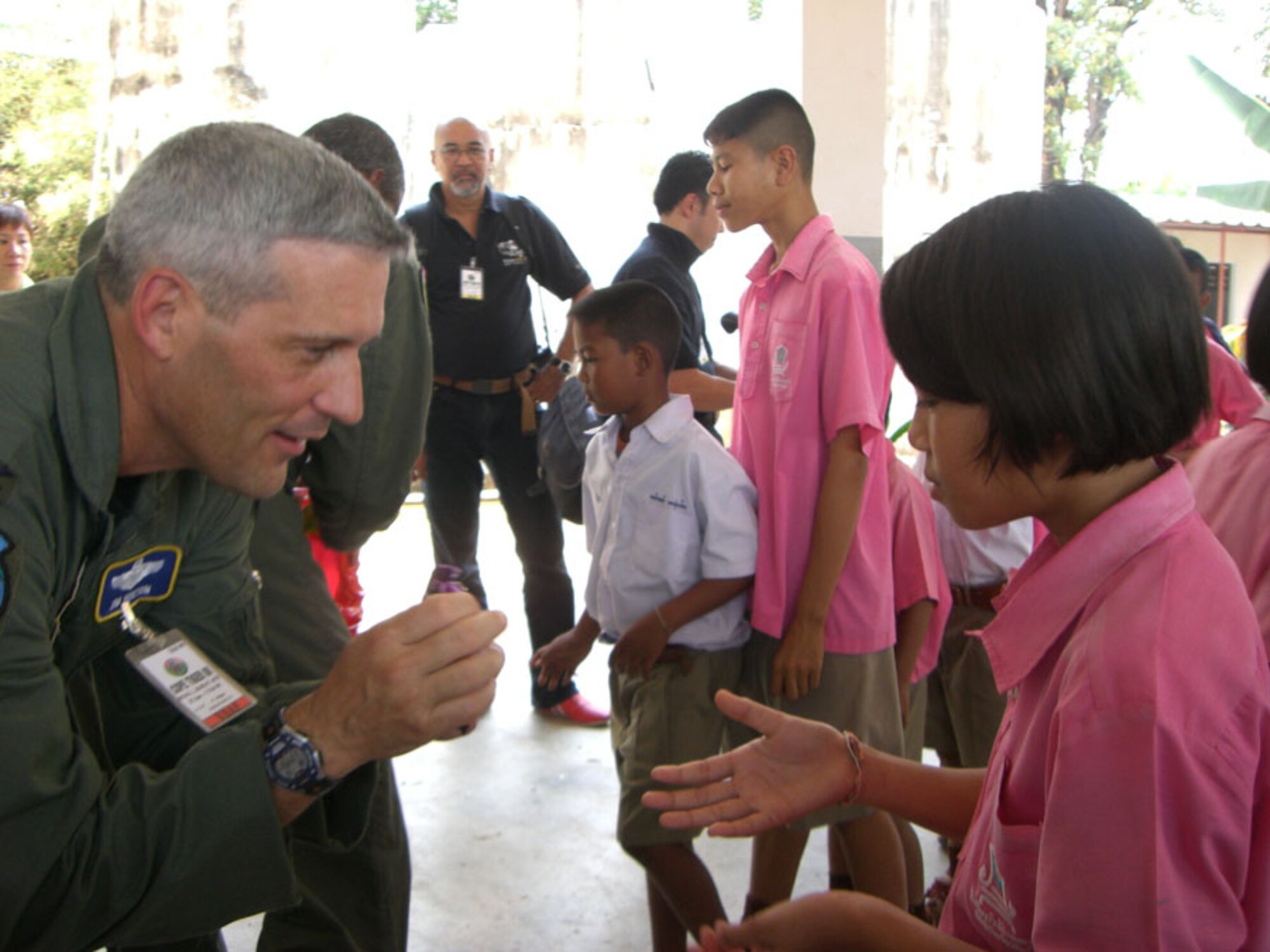 KORAT, Thailand -- Col. James Horton, 13th Air Expeditionary Wing commander for Exercise Cope Tiger 2008, gives candy to a Thai student at Ban Don Phawa School in a rural village outside of Korat, Thailand Jan. 30. Col. Horton presented a donation of school equipment to the school on behalf of Pacific Air Forces and a PACAF medical team provided free medical and dental care to local residents at the school. (U.S. Air Force photo by Capt. Renee Lee)