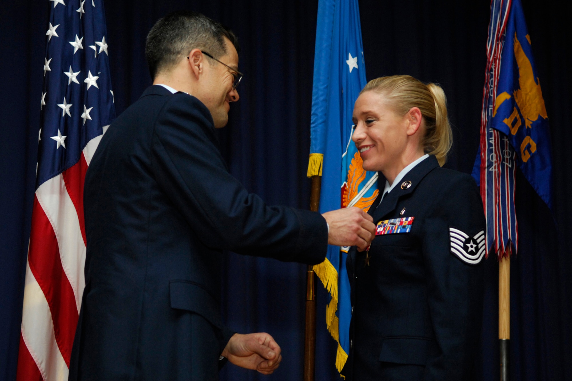 LANGLEY AIR FORCE BASE, Va. -- Col. John DeGoes, 1st Medical Group commander, presents Tech. Sgt. Tracy King with The Bronze Star during a ceremony here Jan. 25. Sergeant King, 1st Aerospace Medicine Squadron aerospace technician, is the first in her Air Force Specialty Code to receive this award. The Bronze Star Medal is awarded for bravery, acts of merit or meritorious service. (U.S. Air Force photo/Airman Gul Crockett)
