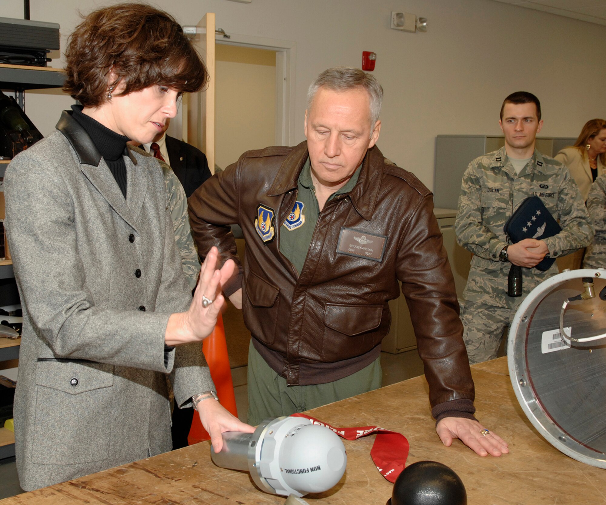 EGLIN AIR FORCE BASE, Fla. -- Lynda Rutledge, director of the 708th Armament Systems Group, discusses the Joint Attack Direct Munition's Quick Reaction Capability program with General Bruce Carlson, Air Force Materiel Command commander.  The Laser sensor will fit on the front of the weapon, adding the capability to attack moving targets. General Carlson visited Eglin Jan. 31. (USAF photo by Craig McDonnell)