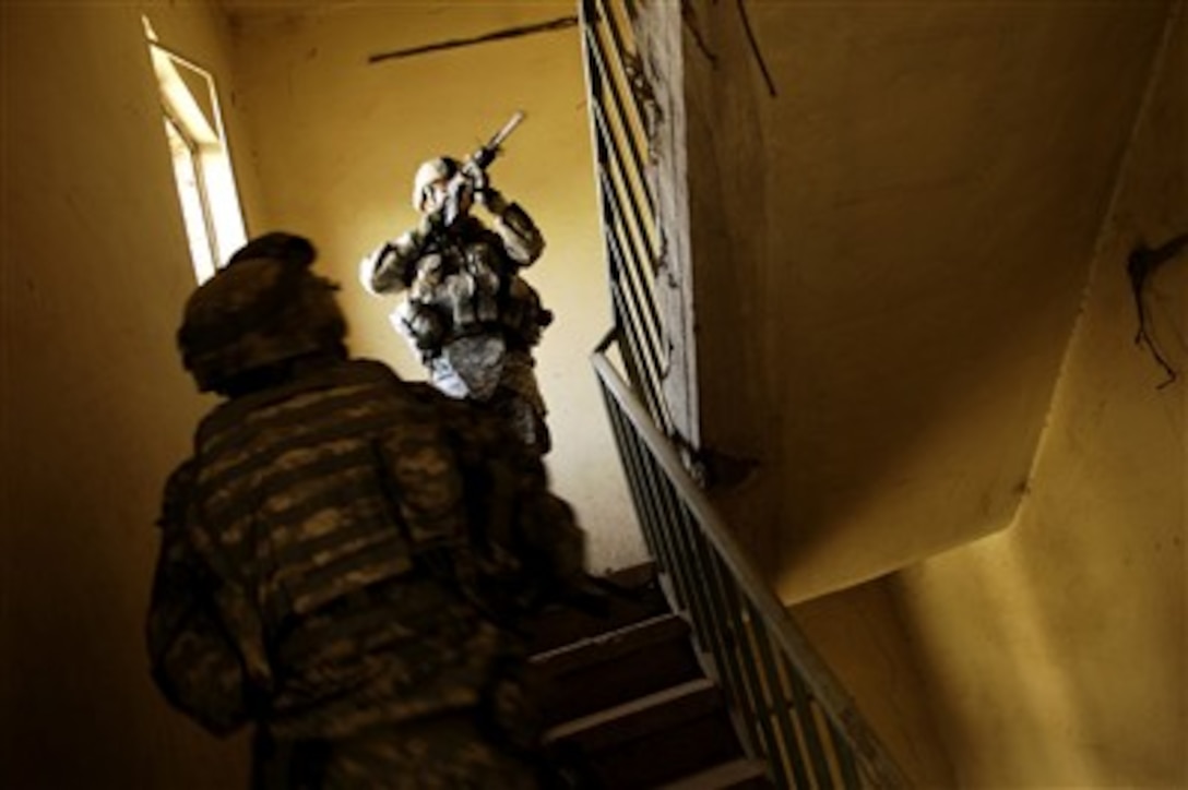 U.S. Army Sgt. 1st Class Chuck Cutler, of 401st Civil Affairs Battalion, clears the stairwell of an abandoned factory during an assessment mission at the Hateen Industrial Park in Baghdad, Iraq, on Jan. 21, 2008.  