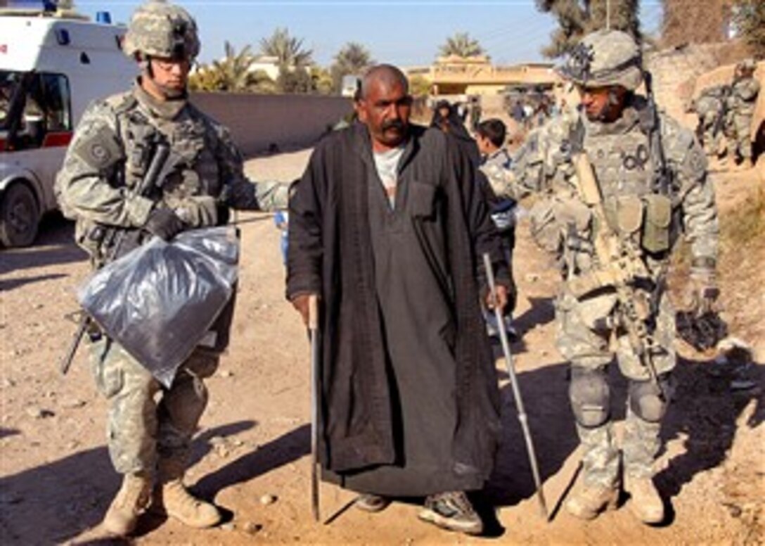 U.S. soldiers assigned to 2nd Stryker Cavalry Regiment, 2nd Infantry Division, help an injured Iraqi man home during Operation Wolfpack Harvest, Muqdadiyah, Iraq, Jan. 21, 2008. 
