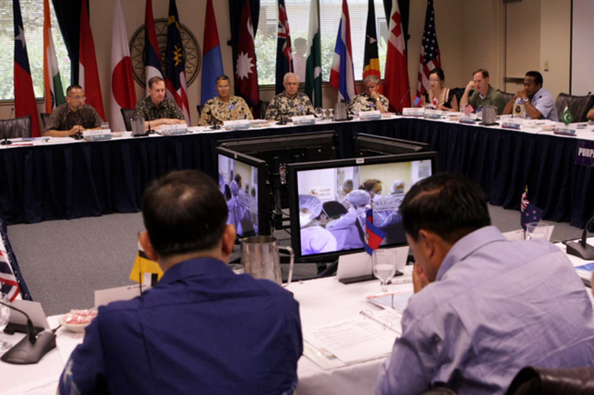 HONOLULU -- Lt. Col. John Oh, from PACAF International Health Affairs (upper left) briefs Asia-Pacific senior executives at the Transnational Security Cooperation Course held at the Asia-Pacific Center for Security Studies in Waikiki June 16. Colonel is Oh is discussing lessons learned from the 2005 SARS outbreak.  To his immediate left is Lt. Gen. (ret) Ed Smith, APCSS Director, and Brig. Gen. (ret) James Hirai, APCSS Deputy Director. (APCSS courtesy photo)
