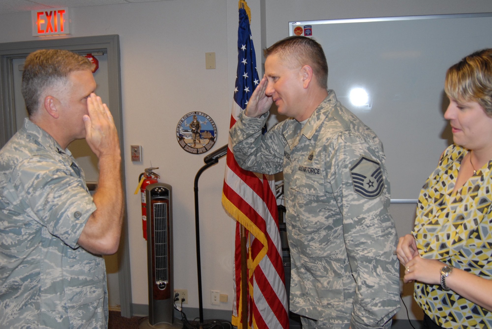 Col. John Flournoy, commander of the 932nd Airlift Wing, returns a salute after performing the oath of enlistment with newly-promoted Master Sgt. William Bassett.  Photo/Maj. Stan Paregien 
