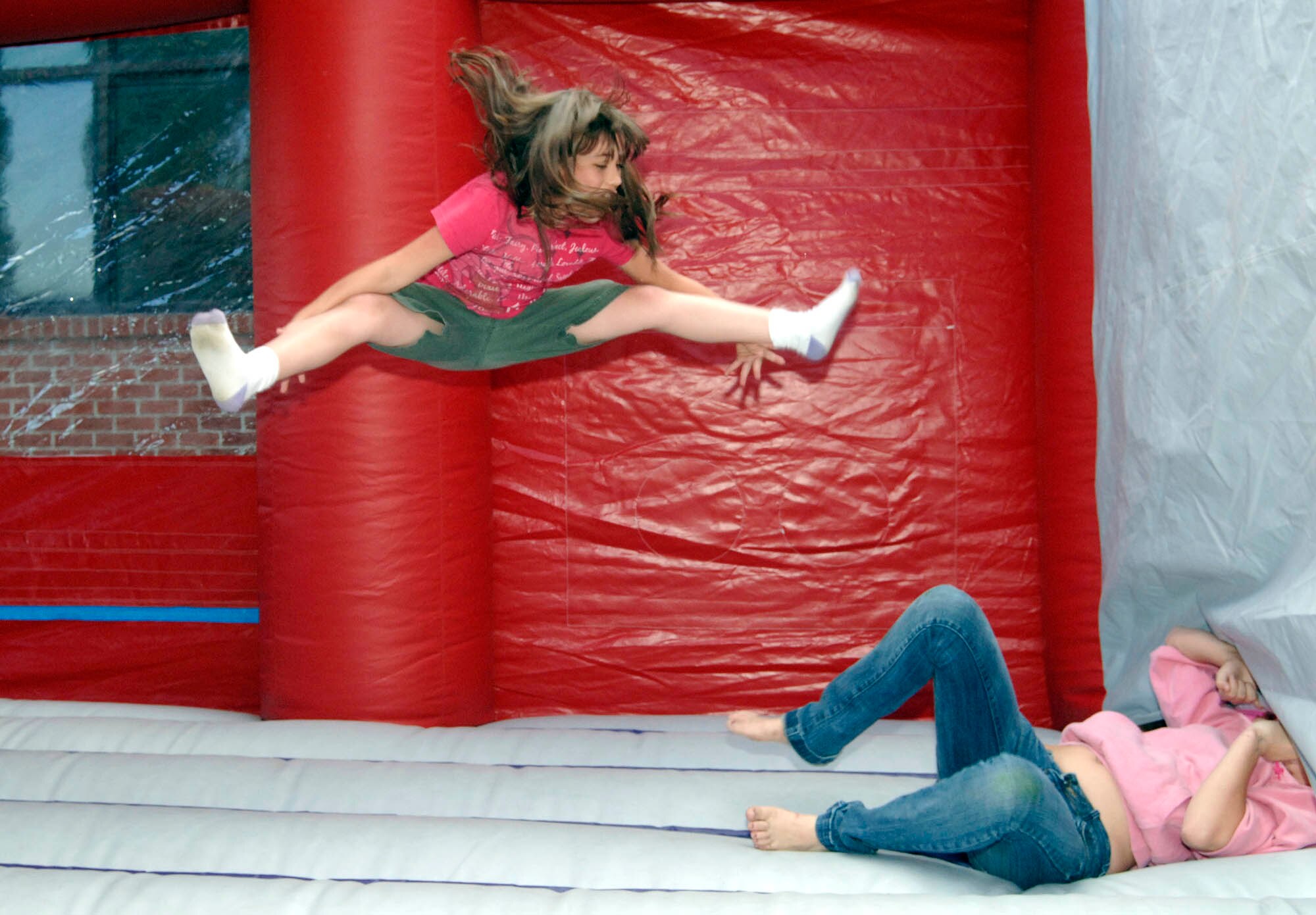 FAIRCHILD AIR FORCE BASE, Wash. – Sierra, 9, daughter of Master Sgt. Amy Barrio, 92nd Maintenance Operations Squadron flight chief, and Master Sgt. Benjamin Barrio, 92nd Logistics Readiness Squadron superintendent, jumps on the bouncer at the Deployed Spouses Dinner at the Dell Community Center June 26. (U.S. Air Force photo / Staff Sgt. JT May III)



