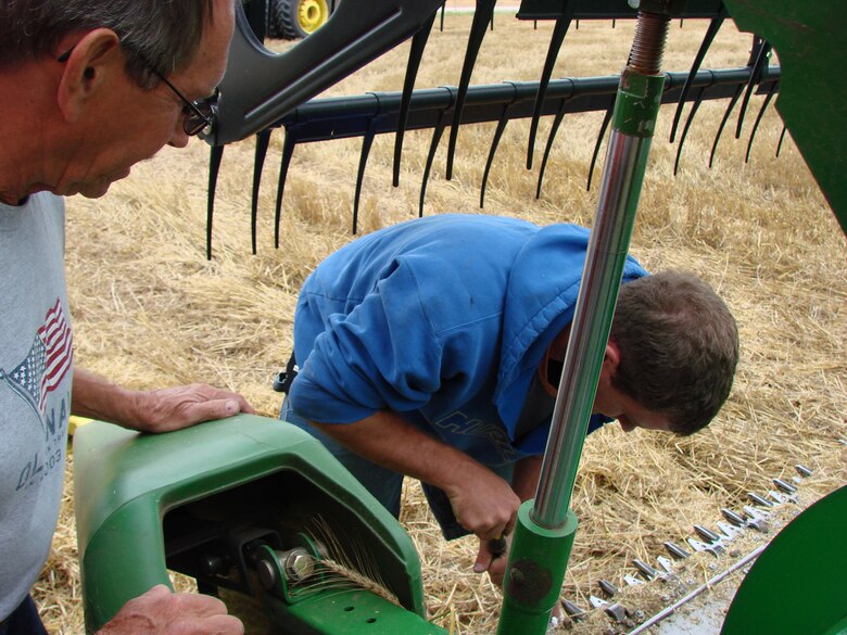Carrier Okla. mayor Kim Ford (left) observes as debris is removed from the shears of a combine. (U.S. Air Force photo by 2nd Lt. Agneta Murnan)