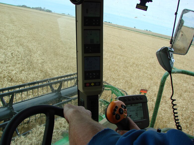 A Minnesota harvesting team member operates a 9770 John Deere combine equiped with controls and instrumentation displaying land pitch and height variations, crop thickness, weather and speed data, ensuring that the wheat is harvested in the most clean and efficient manner possible. (U.S. Air Force photo by 2nd Lt. Agneta Murnan)  