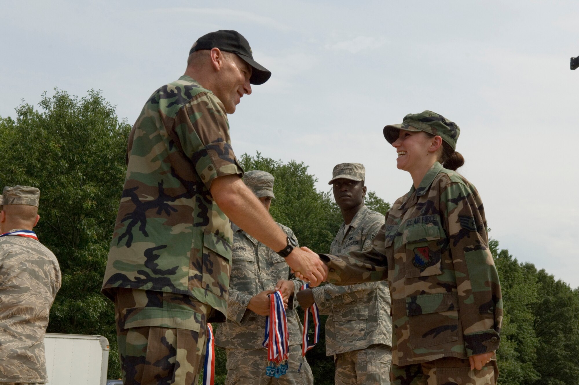 Staff Sgt. Gina Lauber (right) shakes hands with Col. Tom Schluckebier during the Heroes' Homecoming ceremony June 27 at Hanscom Air Force Base, Mass. The ceremony paid tribute to more than 50 base Airmen who were deployed over the past six months, as well as Airmen's families. Sergeant Lauber is assigned to the 66th Medical Group, and Colonel Schluckebier is the 66th Air Base Wing commander. (U.S. Air Force photo/Rick Berry) 
