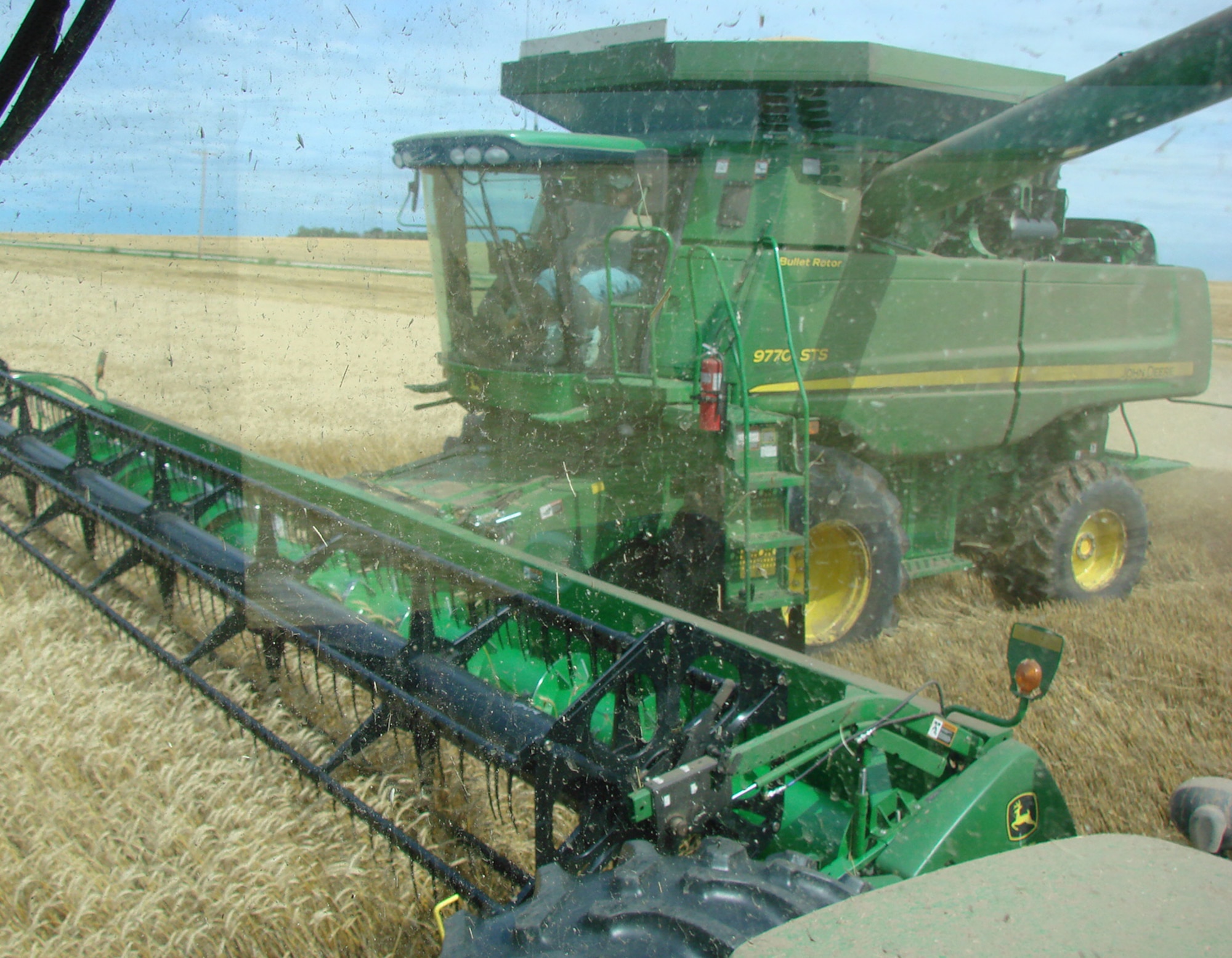 Debris goes flying as a crop is harvested by a combine in Carrier, Okla. The grain is transported by truck to a grain elevator, where it is shipped to other processing destinations before reaching consumers. (U.S. Air Force photo by 2nd Lt. Agneta Murnan)