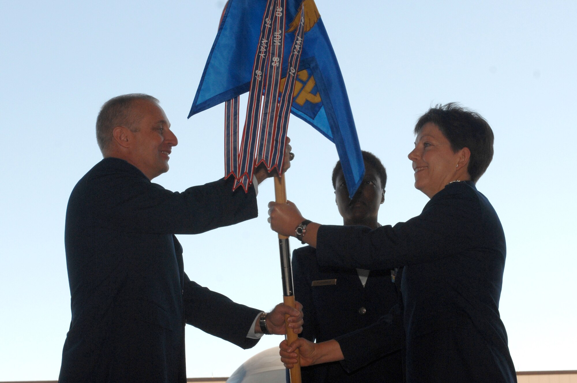 WHITEMAN AIR FORCE BASE, Mo., -- Brig. Gen. Garret Harencak, 509th Bomb Wing commander, presents Col. Kathleen M. Dunn-Cane with the 509th Medical Group guidon during a change of command ceremony here June 30. Colonel Dunn-Cane assumed command of the 509th MDG from Col. Gloria Twilley. (U.S. Air Force photo/Senior Airman Jessica Snow)