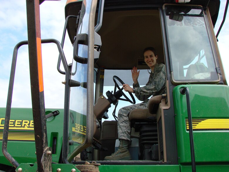 Second Lieutenant Agneta Murnan, 71st Flying Training Wing Public Affairs chief, rides in a 9770 John Deere combine as part of an impromptu base-community exchange. (Courtesy photo by George Ann Ford)