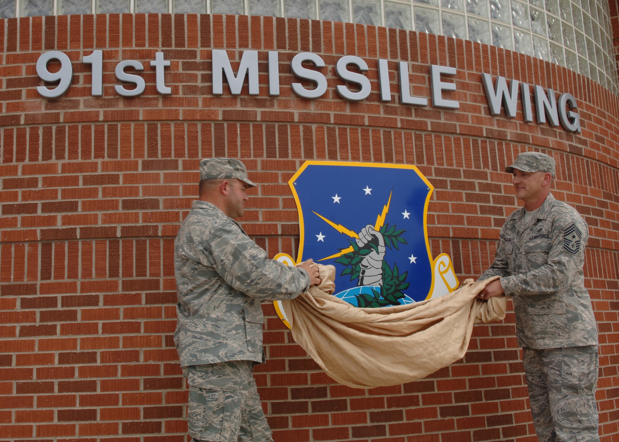 MINOT AIR FORCE BASE, N.D. -- Col. Christopher Ayres , 91st Missile Wing Commander and Chief Master Sgt. Mark Brejcha, 91st MW command chief master sergeant, unveil  the new Missile Wing sign during a redesignation cermony here July 1st. The 91st MW’s mission has been important to the safety and security of our nation for 40 years. (U.S. Air Force photo by Airman 1st Class Sharida Bishop)