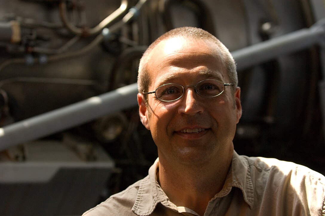 LANGLEY AIR FORCE BASE, Va. -- Allen Hoilman, Virginia Air and Space Center curator and director of exhibits and collections, stands in front of an F100-100 jet engine on exhibit the center June 27.   (U.S. Air Force photo/Staff Sgt. Barry Loo)